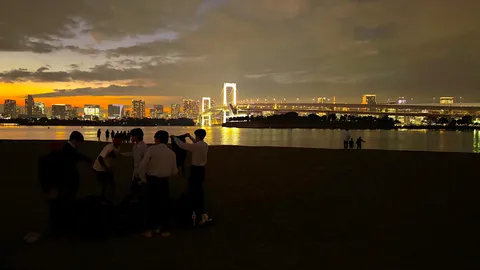 夕暮れ、橋と若者たちのシルエット