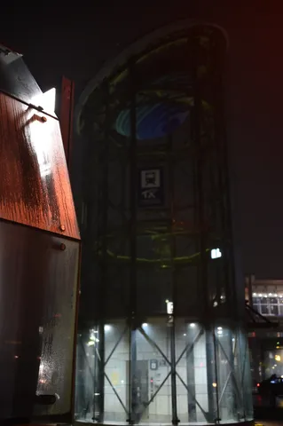夜のガラス塔と雨の影