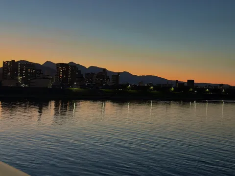 夕暮れの川と灯りの揺らぎ
