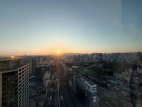 都市パノラマと朝陽のコントラスト