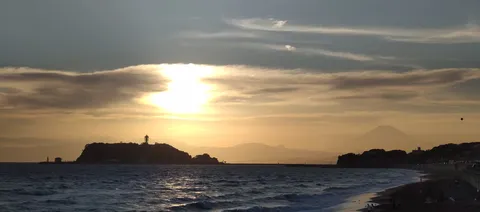 茜色に染まる雲と灯台のシルエット