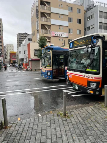 雨の街角に止まるバス