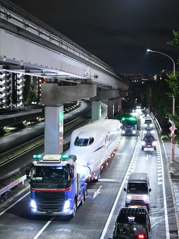 夜の街を運ばれる新幹線の先頭車