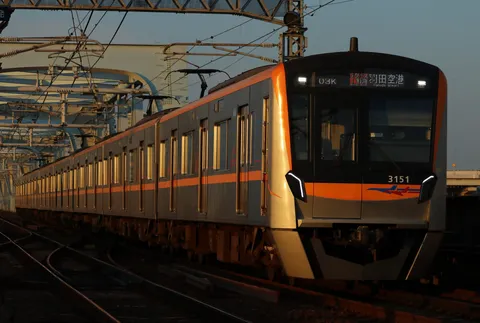 夕陽を浴びて疾走する通勤電車