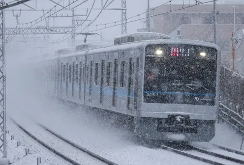 吹雪の中を走る銀色の列車