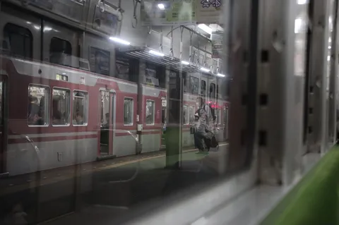 夜の駅、反射と人影の一瞬
