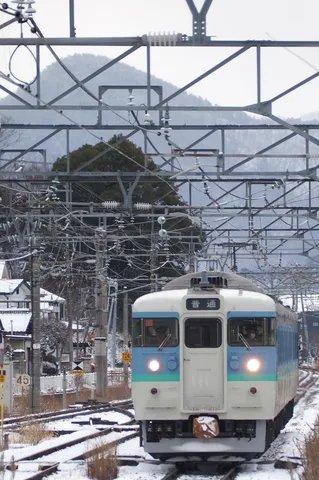 雪に染まる線路と普通列車