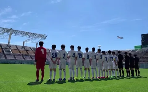 グラウンドに並ぶ背中と空