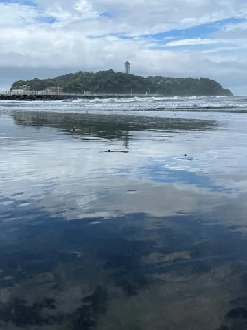 波と灯台が映える海辺の風景