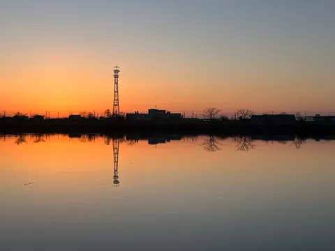 夕暮れ時の水辺、鉄塔のシルエット