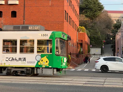 夕暮れの街角、緑の路面電車