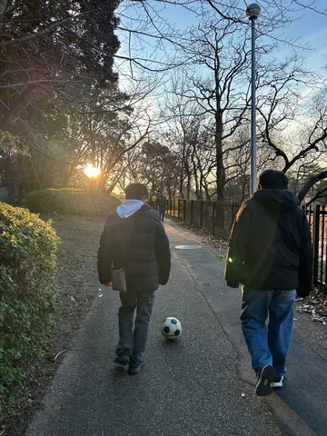 夕暮れ時の公園、サッカーボールと散歩