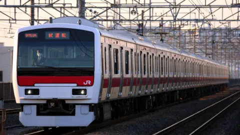 光射す線路を進む試運転列車
