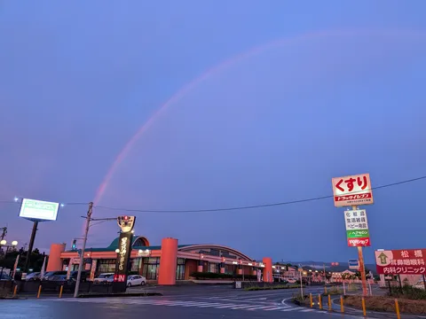 夕暮れに虹がかかるドラッグストア