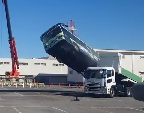 クレーンで吊られるバス？