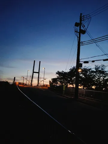 夕暮れの橋、灯る街灯