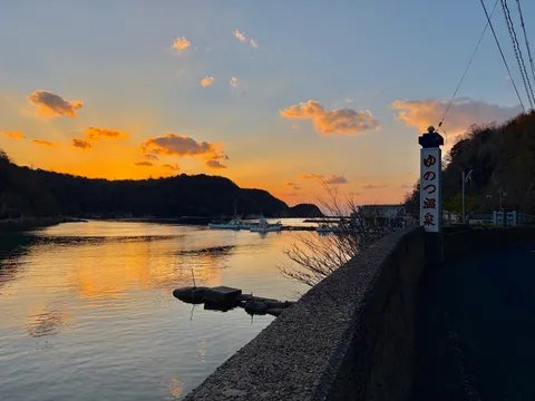 まぶしい夕焼けと温泉看板の競演