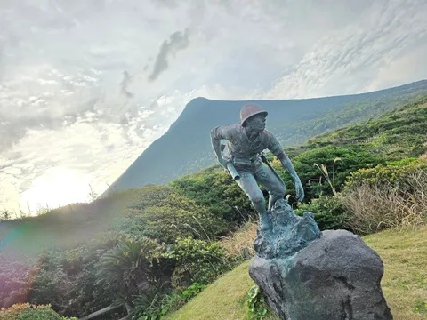 光を浴びる山上の像