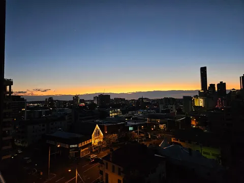 夕暮れの街に灯る影