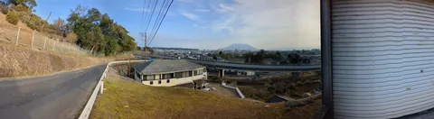 坂道の先に広がる街と山