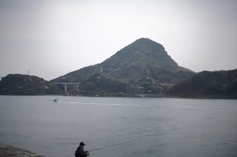 釣り人と霧のかかる山々