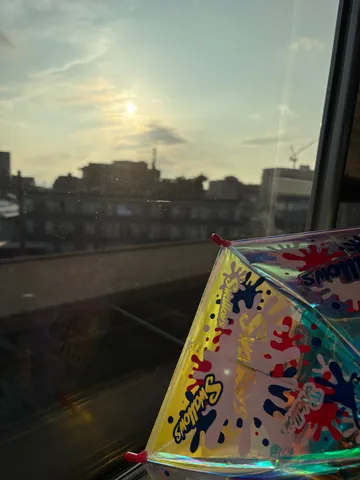 夕暮れの窓辺、カラフルな傘
