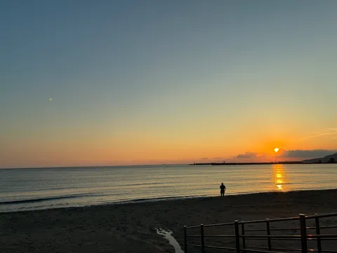 月と夕日、海辺のひとり旅