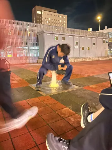 水しぶきとスマホ、夜の交差点