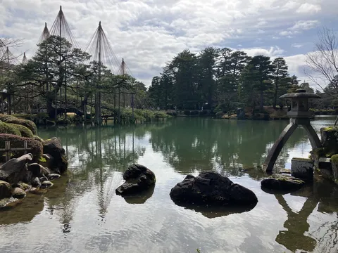 静寂の水面に映る、灯籠と松の風景