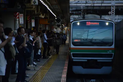 駅のホーム、日常の光景と到着する列車