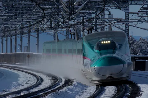 雪煙をまとい駆ける緑の列車