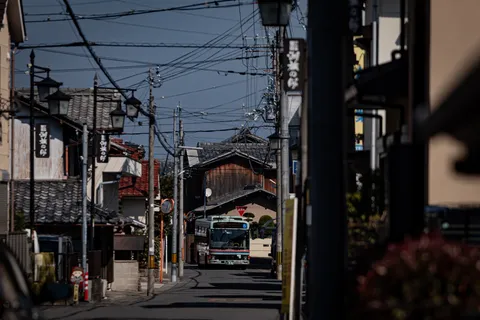 路地の奥、電線とバス