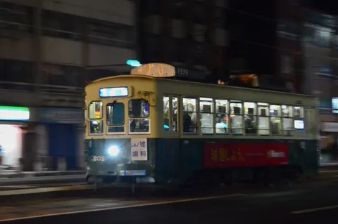 夜を駆ける路面電車の光跡