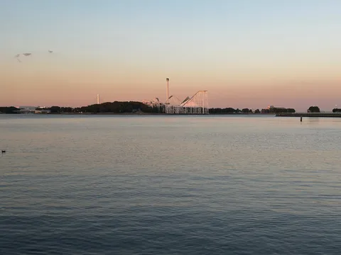 夕暮れ時の遊園地と静かな水面
