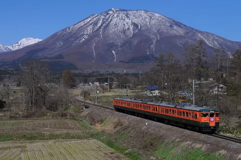 雪化粧の山とオレンジ色の列車