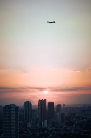 夕暮れの都市と飛行機
