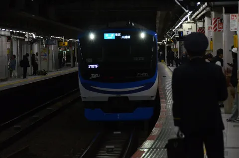 夜の駅に滑り込む青い列車