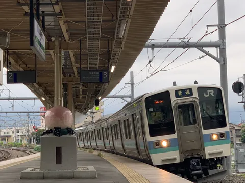 駅のホームに列車と巨大な桃