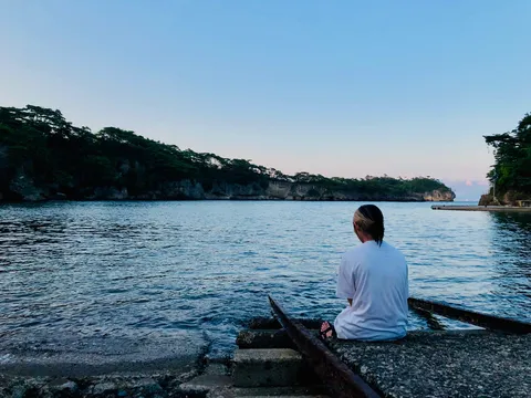 湾を眺める背中、何思うやら