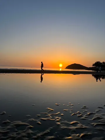 夕陽に染まる水辺のシルエット