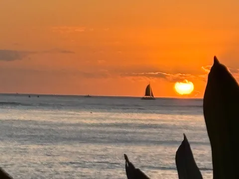 水平線に沈む夕日とヨット