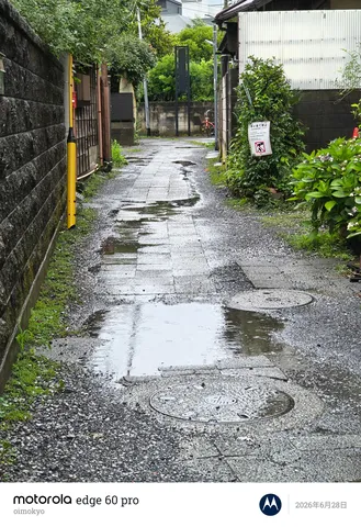 雨上がりの路地裏、水たまりに映る空