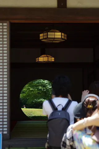 丸窓越しの緑と人のシルエット