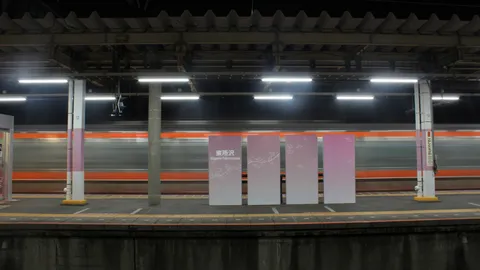 疾走する夜の駅、幻想的な光の帯