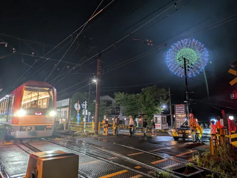 電車と花火、夏の夜の交差点
