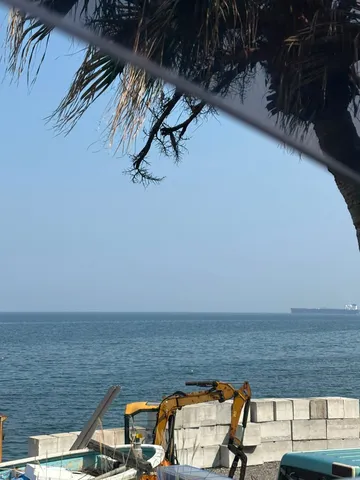 海辺の建設風景、遠くに船
