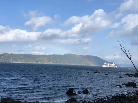 虹とフェリー、海辺の風景