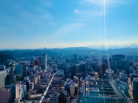 都会の空に輝く太陽、広がる街並み
