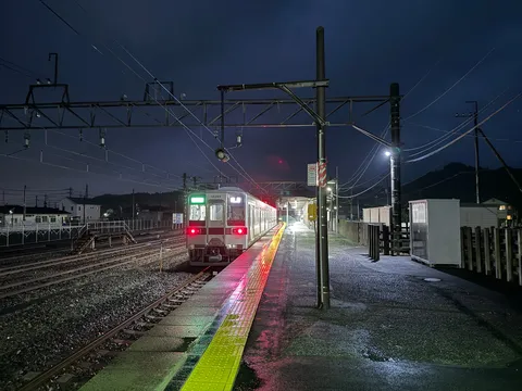 雨上がりの夜、駅の灯りが静かに映る