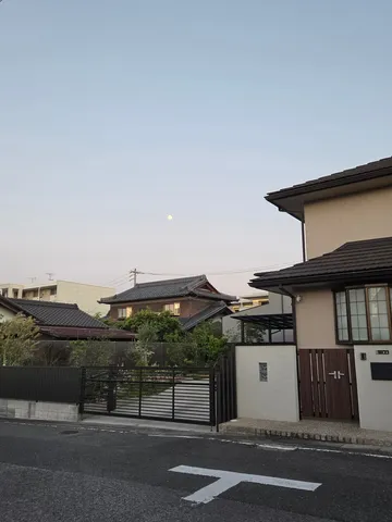 空に浮かぶ月と日本の静かな街並み